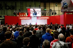 Una gran multitud se reúne para escuchar al presentador Stuart Codling entrevistando a Charles Leclerc, Ferrari en el escenario de Autosport