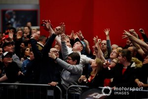 La mercancía de Ferrari se lanza a la multitud frente al escenario de Autosport